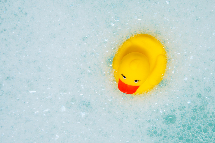 Bath toy duck in white foam bubbles