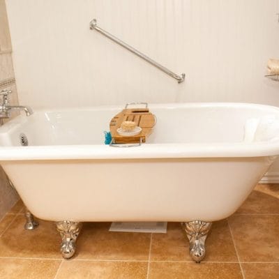 Clawfoot tub with telephone-style faucet and angled wall grab bar