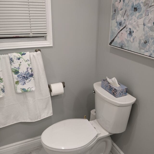 Toilet beside a window in a renovated bathroom