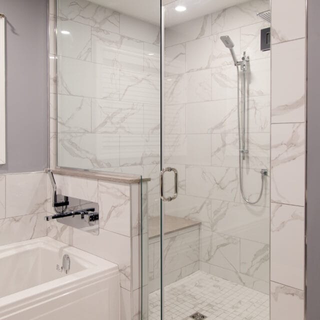 Glass walk-in shower next to a soaker tub