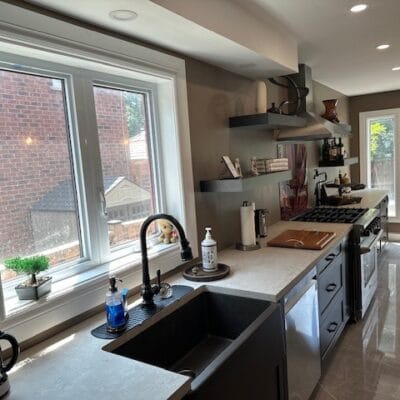 Kitchen with a black sink and faucet below a double window