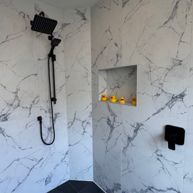 Black rain shower head, hand shower and tiled niche